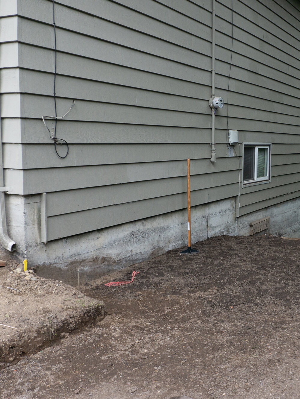 Leveling out the dirt for a diy paver and gravel patio and walkway by the savvy heart.jpg