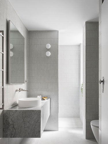 White stacked tile bathroom with tiled walls