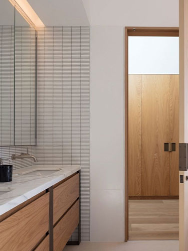 white stacked tile with wood vanity and marble countertops